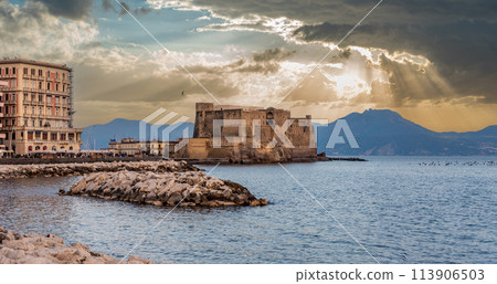 Scenic sunbeams after rain at iconic Castel dell'Ovo in the Gulf of Naples, Italy 113906503