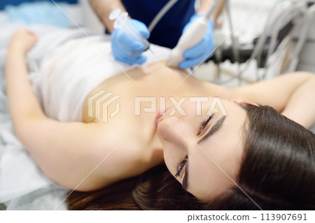 Mammalogist doctor examines woman breasts and lymph nodes during appointment. Skillful oncologist puncture of mammary glands of young patient under review ultrasound for diagnosis of breast cancer Mammalogist doctor examines woman breasts and lymph nodes during appointment. Skillful oncologist puncture of mammary glands of young patient under review ultrasound for diagnosis of breast cancer 113907691