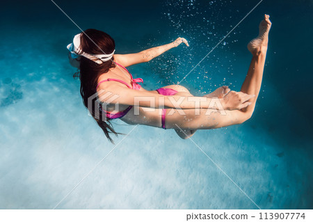 Woman with ideal body snorkeling in blue sea. Swimming underwater in ocean on Oahu Woman with ideal body snorkeling in blue sea. Swimming underwater in ocean on Oahu 113907774