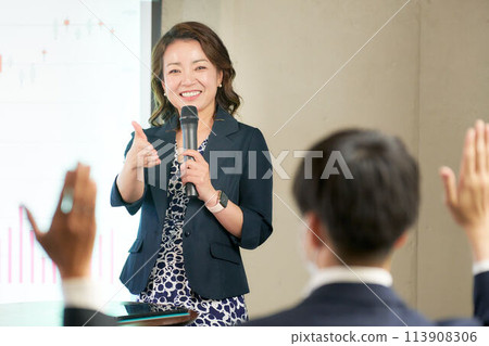 Middle-aged female seminar lecturer giving a lecture 113908306