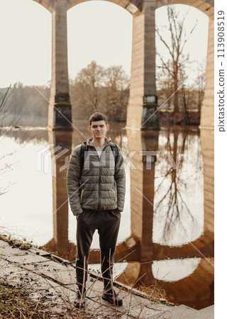 Youthful Exploration: 17-Year-Old Teen in Stylish Jacket by Neckar River and Historic Bridge in Bietigheim-Bissingen, Germany Youthful Exploration: 17-Year-Old Teen in Stylish Jacket by Neckar River and Historic Bridge in Bietigheim-Bissingen, Germany 113908519