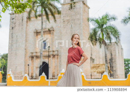 Woman tourist explores the vibrant streets of Valladolid, Mexico, immersing herself in the rich culture and colorful architecture of this charming colonial town 113908894