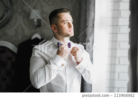 Beautiful man, groom posing and preparing for wedding Beautiful man, groom posing and preparing for wedding 113908982