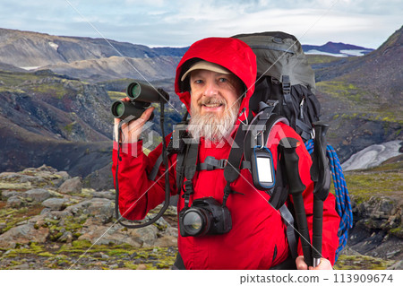 happy bearded man traveler with hiking equipment on mountain landscape happy bearded man traveler with hiking equipment on mountain landscape 113909674