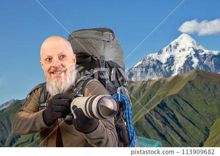 bearded man tourist photographer with a backpack photographs the beauty of nature  113909682