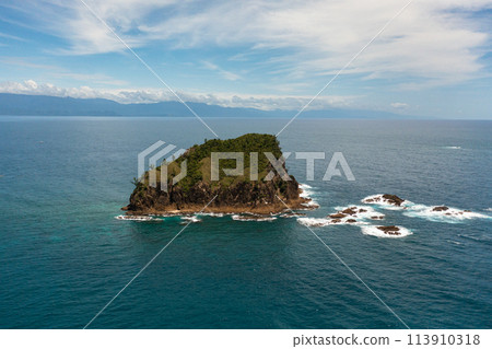 Aerial drone of rocky island in the ocean and sea surf. Santa Ana, Cagayan. Philippines. Aerial drone of rocky island in the ocean and sea surf. Santa Ana, Cagayan. Philippines. 113910318