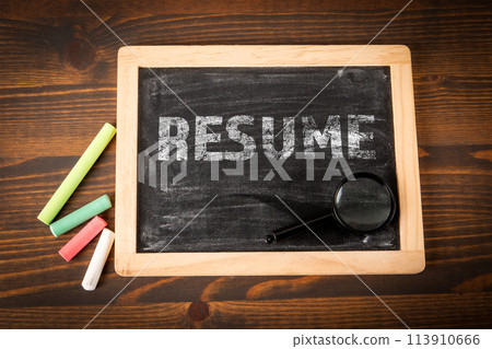 Resume. Chalk board with text and magnifying glass on wood texture background Resume. Chalk board with text and magnifying glass on wood texture background 113910666