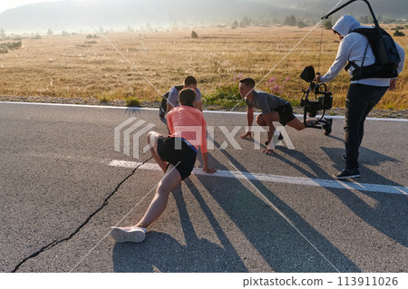 Behind the Lens: Videographer Captures Athletes Warming Up for Morning Run. Behind the Lens: Videographer Captures Athletes Warming Up for Morning Run. 113911026