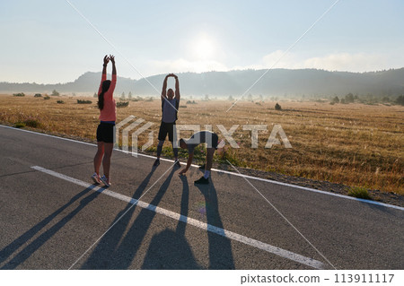 Diverse Athletes Prepare: Dynamic Group Warms Up for Morning Run. 113911117