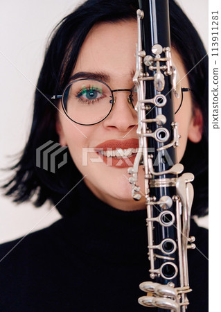Graceful Brunette Musician Posing with Clarinet on White Background Graceful Brunette Musician Posing with Clarinet on White Background 113911281