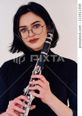 Graceful Brunette Musician Posing with Clarinet on White Background Graceful Brunette Musician Posing with Clarinet on White Background 113911309