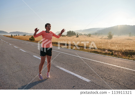 Determined Stretch: Athletic Woman Embraces Post-Run Flexibility in Nature. 113911321