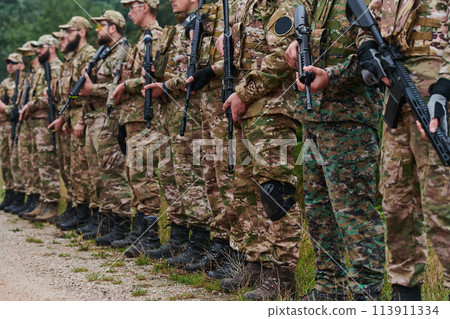Soldier fighters standing together with guns. Group portrait of US army elite members, private military company servicemen, anti terrorist squad Soldier fighters standing together with guns. Group portrait of US army elite members, private military company servicemen, anti terrorist squad 113911334