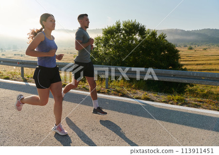 Energized by the beauty of nature, a couple powers through their morning run, their bodies and spirits invigorated. 113911451