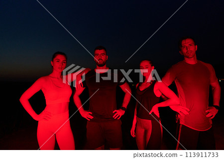 Diverse Athletes Unwind: Post-Marathon Rest Under Red Nighttime Glow. Diverse Athletes Unwind: Post-Marathon Rest Under Red Nighttime Glow. 113911733