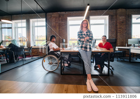 A diverse group of business professionals collaborates in a modern startup coworking center, utilizing a mix of paper-based and technological tools such as mobile phones and computers  113911806