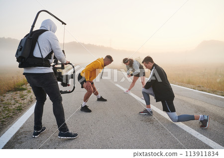 Behind the Lens: Videographer Captures Athletes Warming Up for Morning Run. 113911834