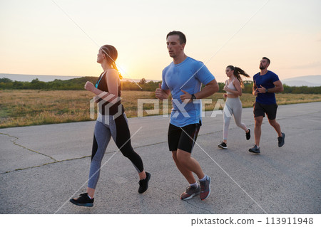A diverse group of runners trains together at sunset. A diverse group of runners trains together at sunset. 113911948