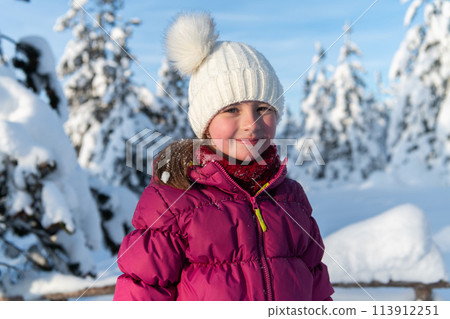 Portrait of a Beautiful Girl Delighting in Sunlight Amidst Snowy Peaks. 113912251