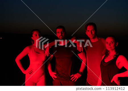 Diverse Athletes Unwind: Post-Marathon Rest Under Red Nighttime Glow. 113912412