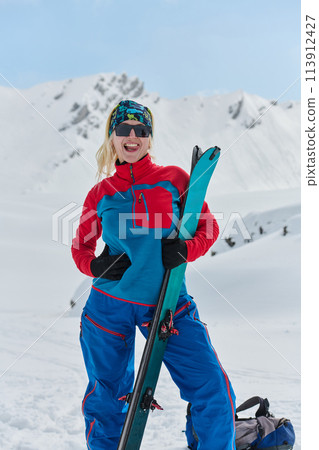 A professional woman skier rejoices after successfully climbing the snowy peaks of the Alps A professional woman skier rejoices after successfully climbing the snowy peaks of the Alps 113912427