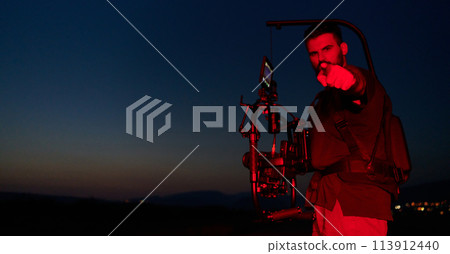 Nighttime Capture: Professional Videographer Films Athletes Running in Red-Lit Darkness 113912440