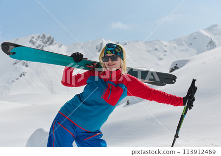 A professional woman skier rejoices after successfully climbing the snowy peaks of the Alps A professional woman skier rejoices after successfully climbing the snowy peaks of the Alps 113912469