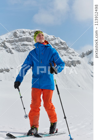 A Skier Scales a Treacherous Alpine Peak 113912498