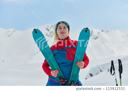 Conquering the Peak: Confident Skier Celebrates Success 113912531