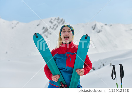 Conquering the Peak: Confident Skier Celebrates Success 113912538