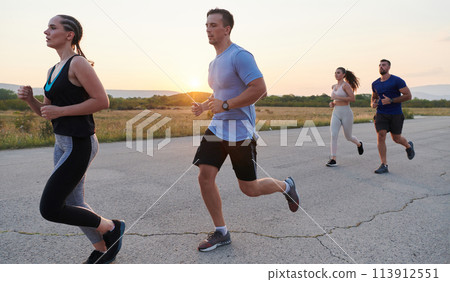 A diverse group of runners trains together at sunset. A diverse group of runners trains together at sunset. 113912551
