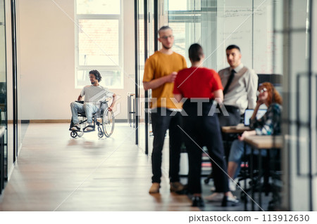 A dynamic group of young entrepreneurs engages in vibrant discussion within a modern glass office space, exploring new business projects and fostering innovation 113912630