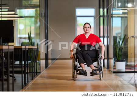 A modern young businesswoman in a wheelchair is surrounded by an inclusive workspace with glass-walled offices, embodying determination and innovation in the business world A modern young businesswoman in a wheelchair is surrounded by an inclusive workspace with glass-walled offices, embodying determination and innovation in the business world 113912752