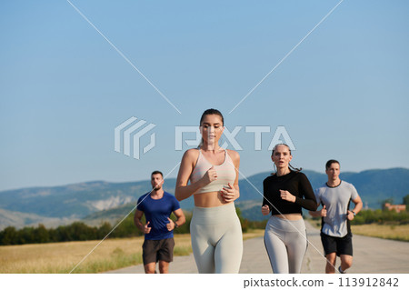 A group of friends maintains a healthy lifestyle by running outdoors on a sunny day, bonding over fitness and enjoying the energizing effects of exercise and nature 113912842