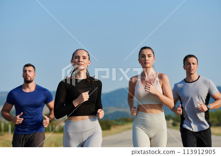 A group of friends maintains a healthy lifestyle by running outdoors on a sunny day, bonding over fitness and enjoying the energizing effects of exercise and nature 113912905