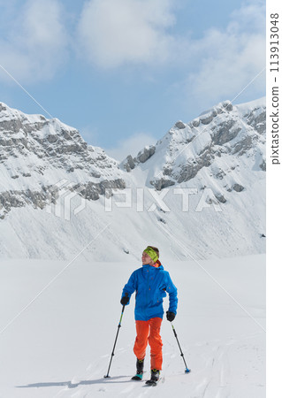 A Skier Scales a Treacherous Alpine Peak 113913048