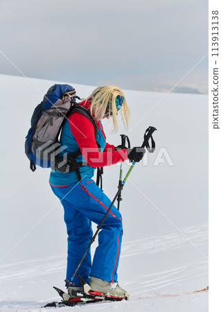 A determined skier scales a snow-capped peak in the Alps, carrying backcountry gear for an epic descent. A determined skier scales a snow-capped peak in the Alps, carrying backcountry gear for an epic descent. 113913138