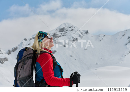 A Female Mountaineer Ascends the Alps with Backcountry Gear 113913239