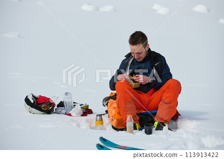 A Skier Takes a Well-Deserved Break to Enjoy the View 113913422