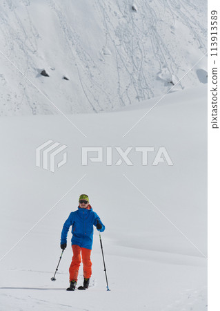A Skier Scales a Treacherous Alpine Peak 113913589