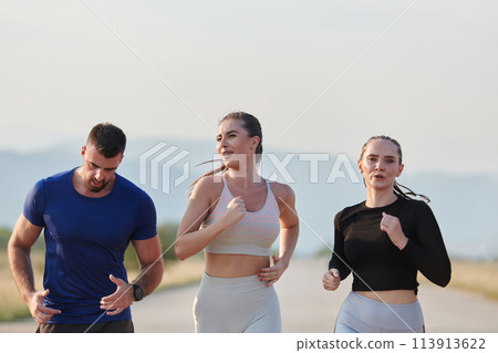 A group of friends maintains a healthy lifestyle by running outdoors on a sunny day, bonding over fitness and enjoying the energizing effects of exercise and nature 113913622