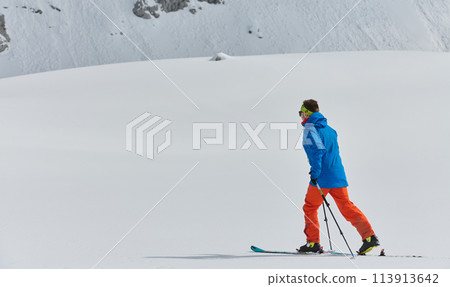 A Skier Scales a Treacherous Alpine Peak 113913642