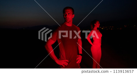 Athlete Strikes a Pose Under Red Nighttime Glow After Intense Daylong Marathon. 113913657