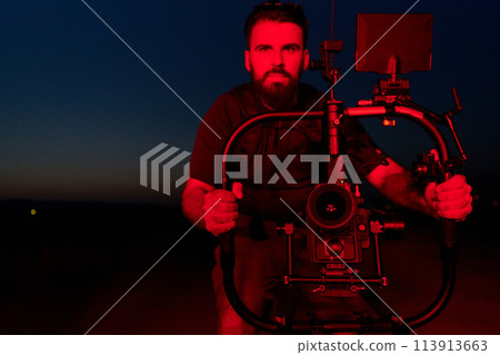 Nighttime Capture: Professional Videographer Films Athletes Running in Red-Lit Darkness 113913663