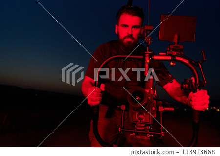 Nighttime Capture: Professional Videographer Films Athletes Running in Red-Lit Darkness 113913668