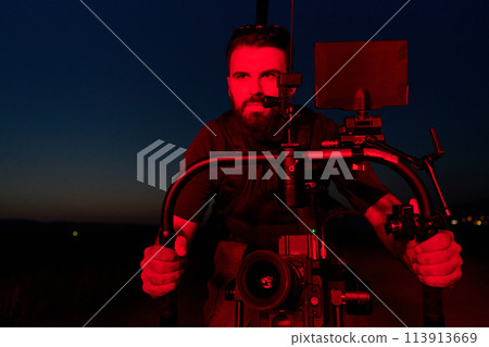 Nighttime Capture: Professional Videographer Films Athletes Running in Red-Lit Darkness 113913669