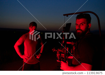 Nighttime Capture: Professional Videographer Films Athletes Running in Red-Lit Darkness Nighttime Capture: Professional Videographer Films Athletes Running in Red-Lit Darkness 113913675