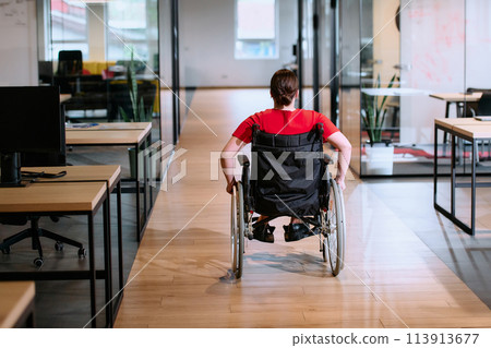 A modern young businesswoman in a wheelchair is surrounded by an inclusive workspace with glass-walled offices, embodying determination and innovation in the business world A modern young businesswoman in a wheelchair is surrounded by an inclusive workspace with glass-walled offices, embodying determination and innovation in the business world 113913677