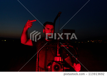 Nighttime Capture: Professional Videographer Films Athletes Running in Red-Lit Darkness 113913692