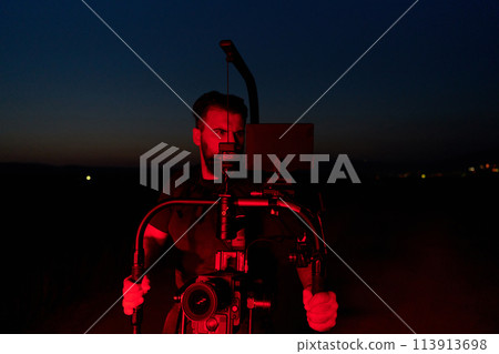 Nighttime Capture: Professional Videographer Films Athletes Running in Red-Lit Darkness 113913698